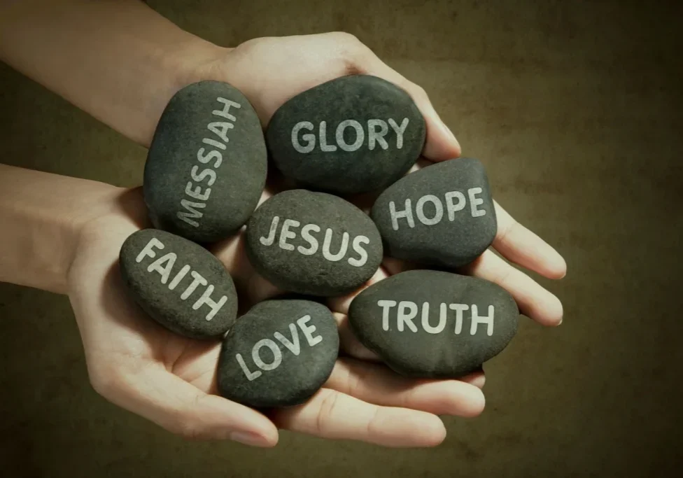 A person holding rocks with words written on them.